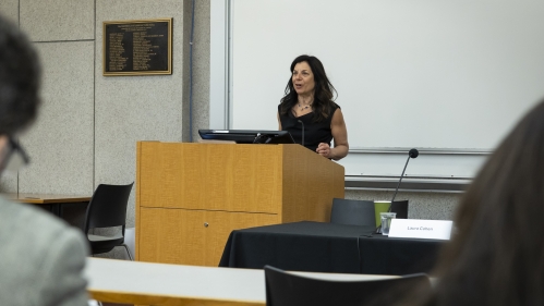 woman professor in black dress speaking at podium
