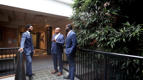 three men in blue suits talking