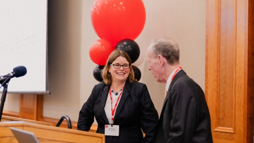 woman looking and smiling at man behind podium