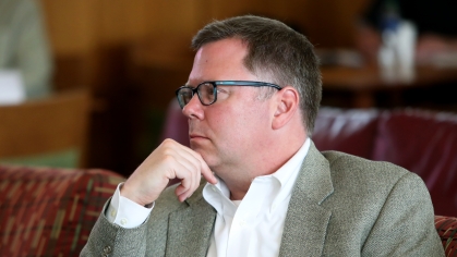Professor sitting with hand to chin