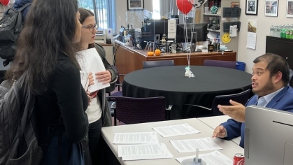 women speaking with man at office desk