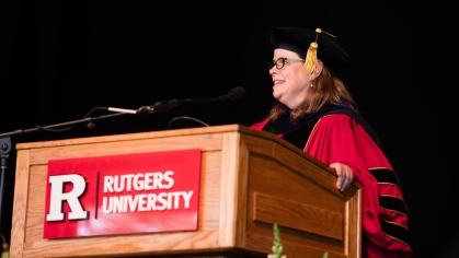 woman in red commencement robe at Rutgers University podium