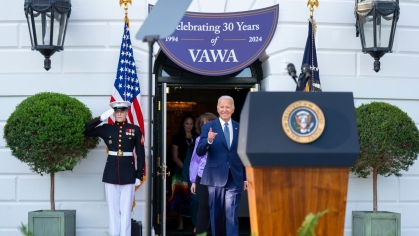 Man in suit walks out of white house to president podium