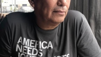 Photograph of a man with white hair in a t-shirt