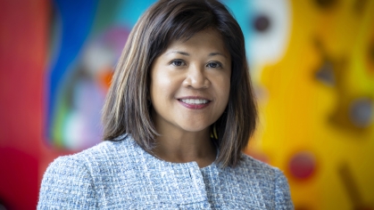 woman smiling in front of blurred art mural