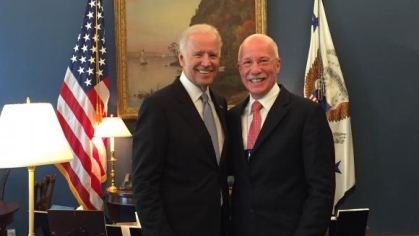 photograph of two men in suits posing next to each other