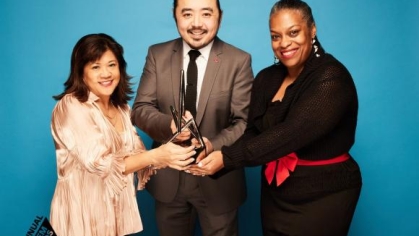 a group of people holding an award and posing for a photograph