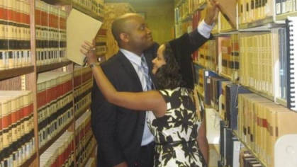 two people putting books on shelves