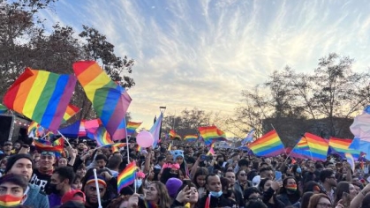 group of people holding rainbow LGBTQIA+ flags