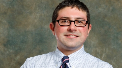 man smiling in shirt, tie and glasses