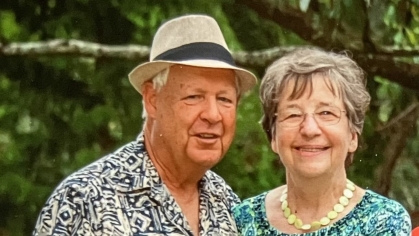 man and woman standing next to each other in colorful print shirts