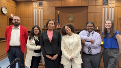 group of men and women smiling and standing next to each other in courtroom