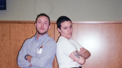 Two people standing back to back with arms folded