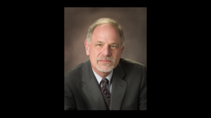 man in suit in front of brown background