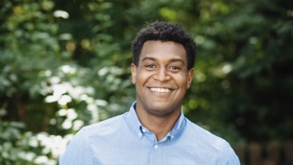 man in blue shirt smiling outdoors