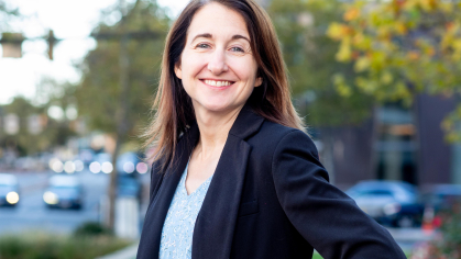 Portrait of a woman with brown hair in a dark navy blazer