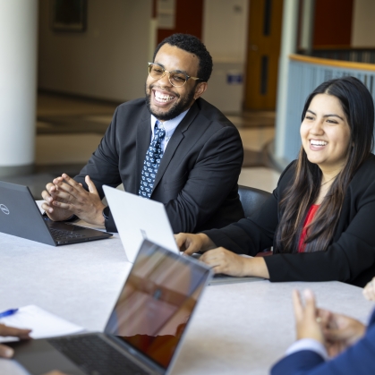 Man and woman smiling and working at laptops