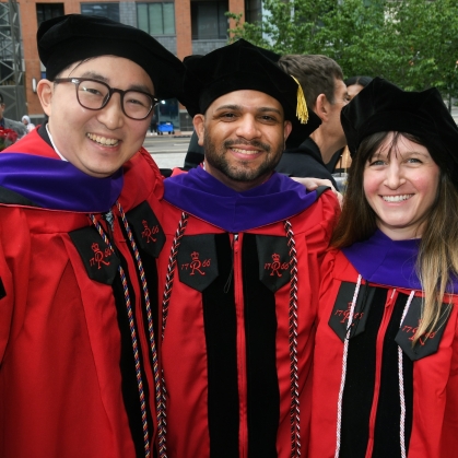 woman and two men in red robes and black caps