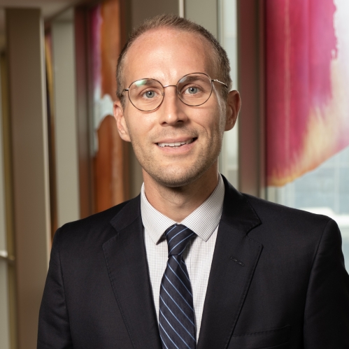 a man with glasses smiling