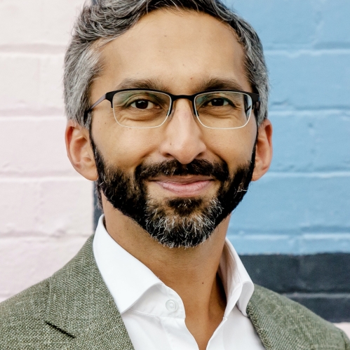 a man with a beard and glasses smiling