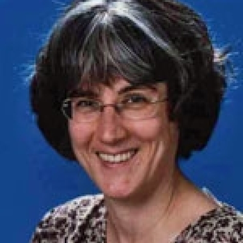 a woman with glasses smiling