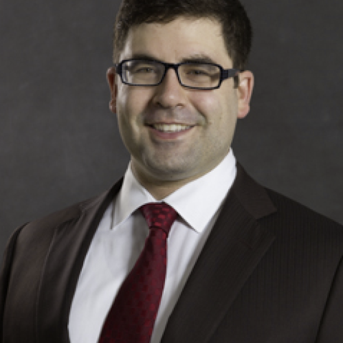 a man with glasses smiling