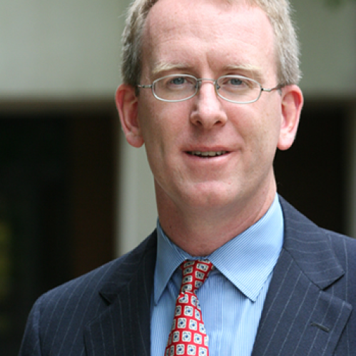 a man with glasses smiling