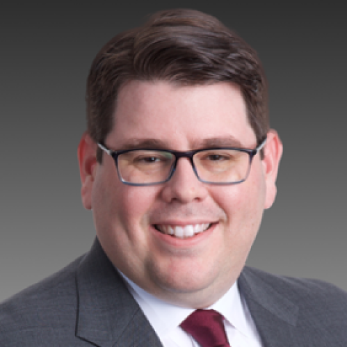 a man with glasses smiling