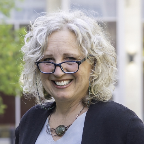 a woman with glasses smiling