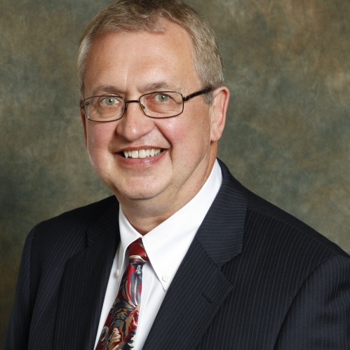 a man with glasses smiling