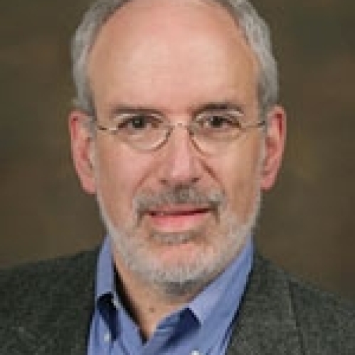 a man with a beard and glasses smiling