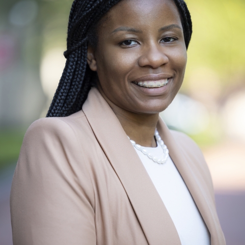 woman in brown blazer smiling