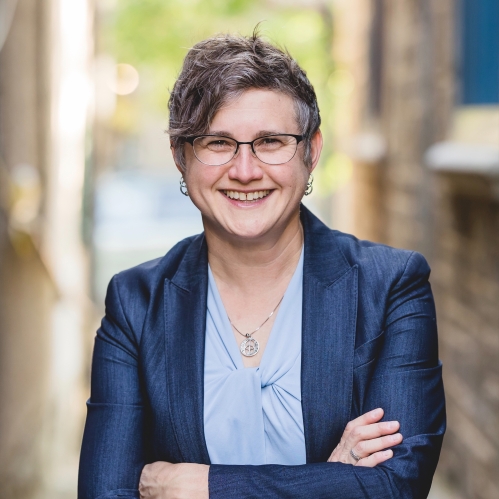 a woman with glasses smiling