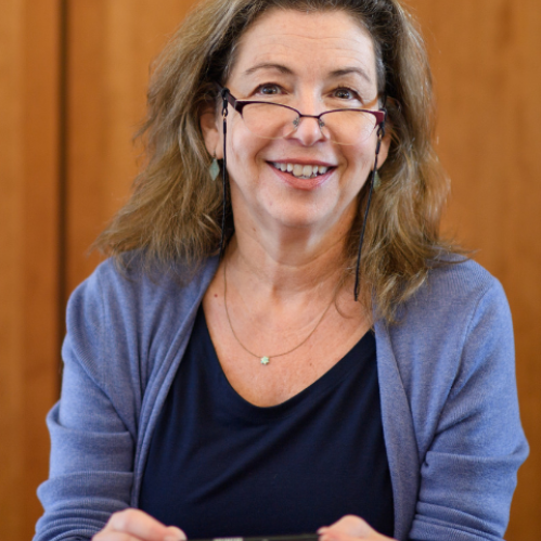 a woman with glasses smiling