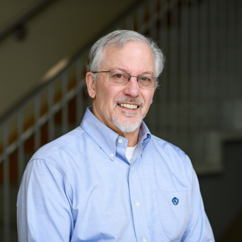 a man with a beard and glasses smiling