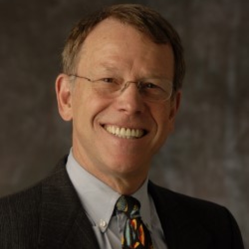 a man with glasses smiling