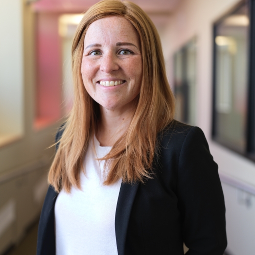women in black blazer smiling