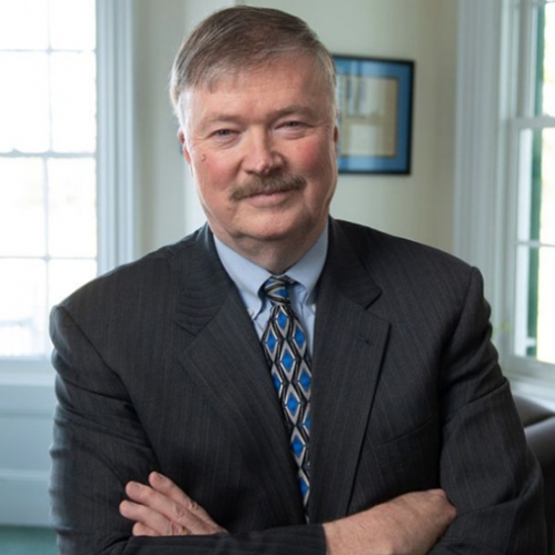 man in suit with folded arms smiling