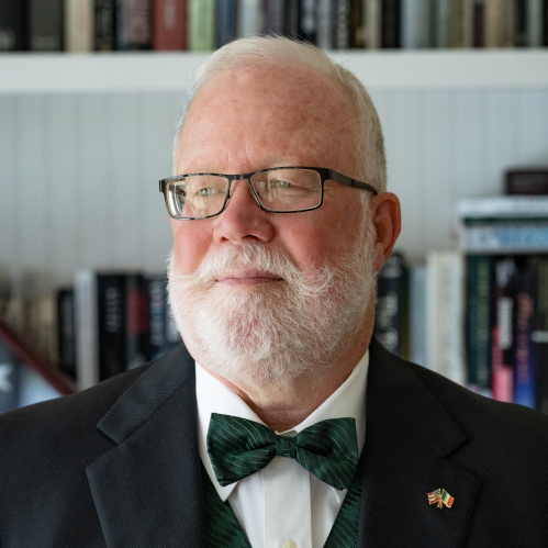 bearded man with glasses and bowtie staring left