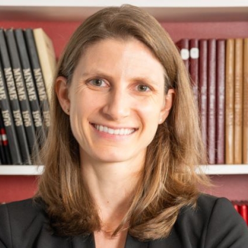 woman smiling in front of bookcase