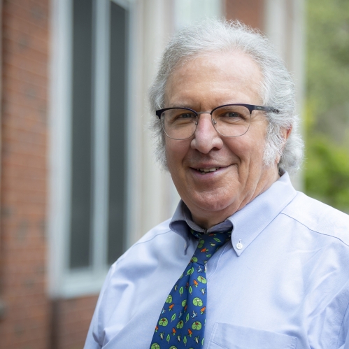 man in glasses, shirt and tie smiling