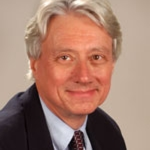 Man grinning wearing blue button down, suit jacket, and tie