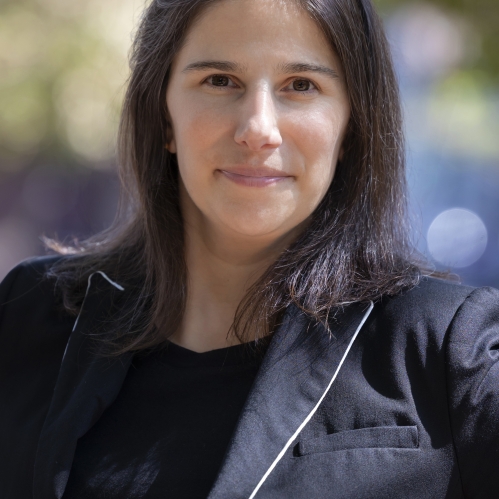 Woman grinning wearing black shirt and black jacket