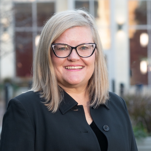 Woman smiling with glasses wearing a black shirt