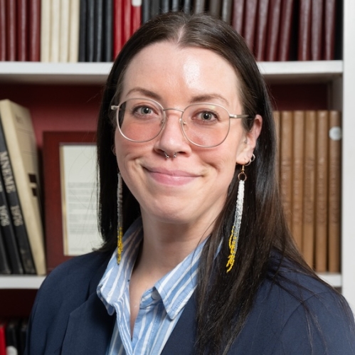 Woman grinning in front of bookcase