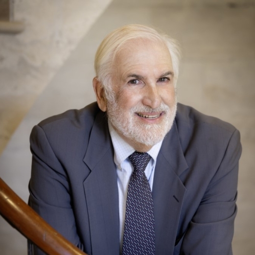 man in blue suit smiling on staircase