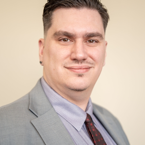 man in grey suit smiling