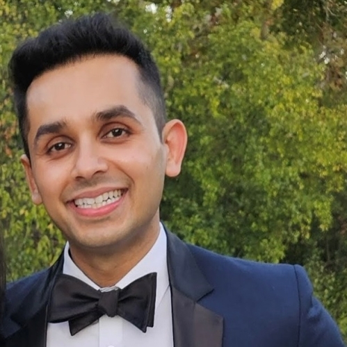 man in blue tux and bowtie smiling