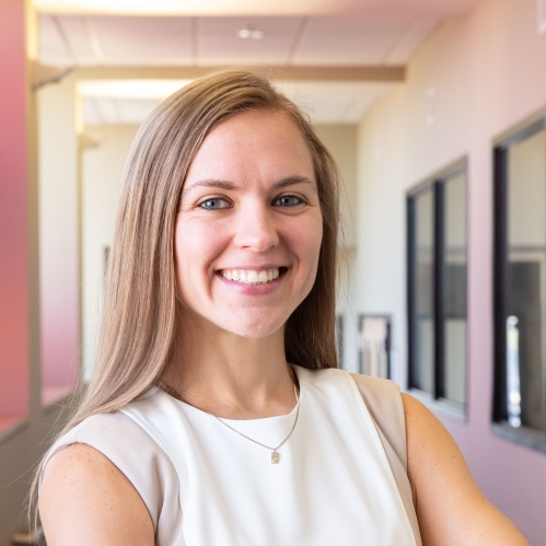 woman in white dress smiling in hallway