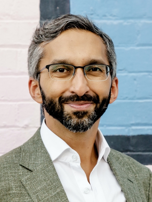 a man with a beard and glasses smiling